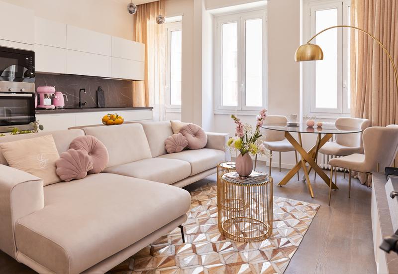 woonkamer met open keuken in glam stijl met gouden en pastelroze accenten