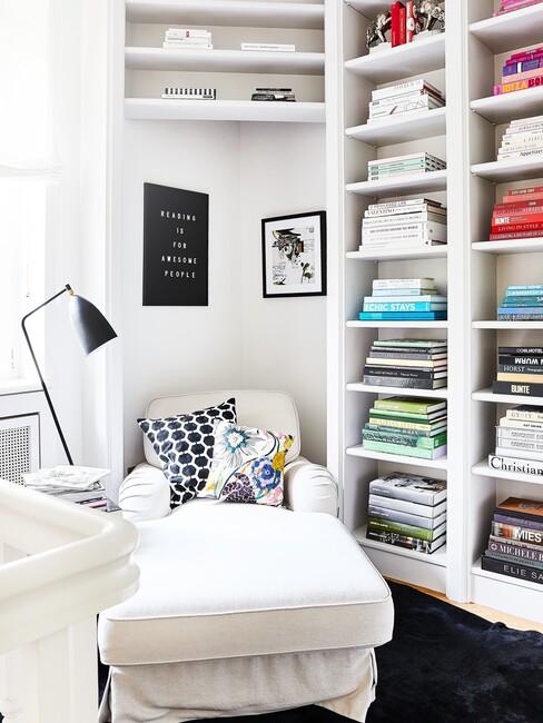 witte loungestoel en boekenkast met decoratieve boeken