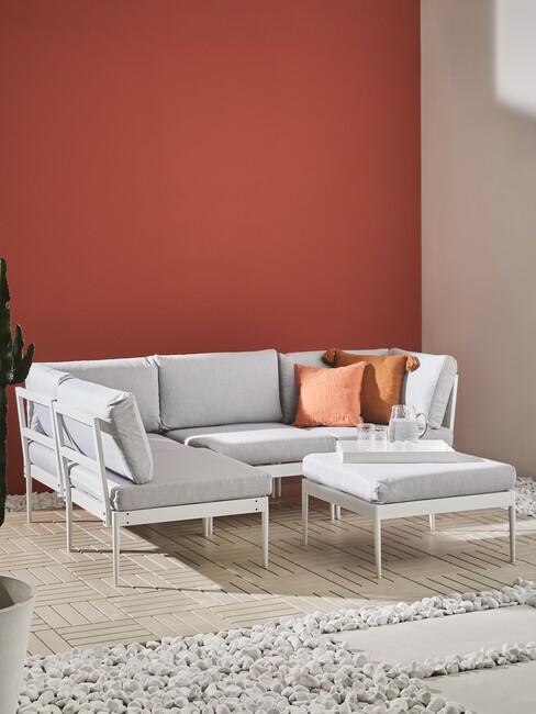terracotta muur en witte loungeset