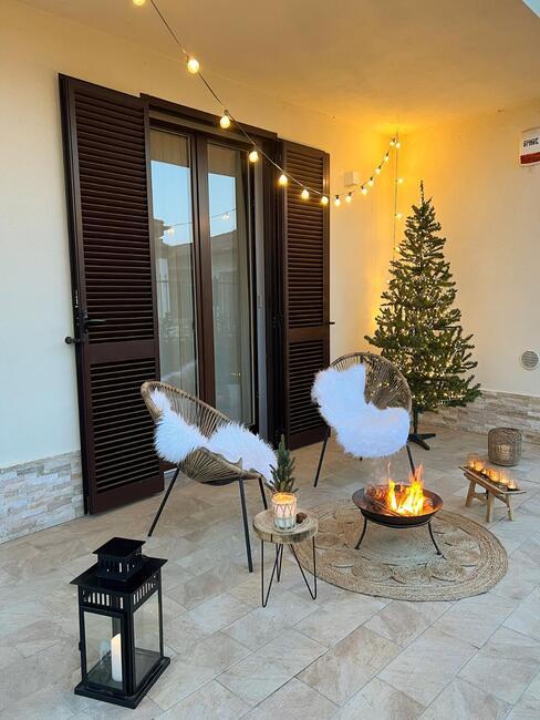 terras met vuurkorf en kerstversiering: een kerstboom en lichtslinger