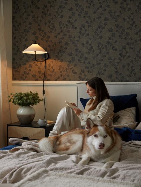 vrouw en hond liggen op bed