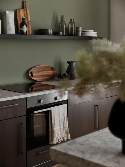 groene muur in keuken met houten kasten