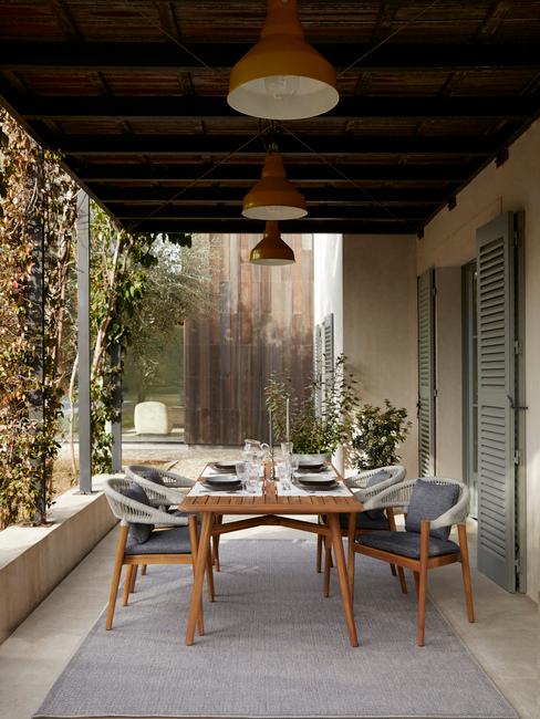 eettafel onder overkapping in grote tuin