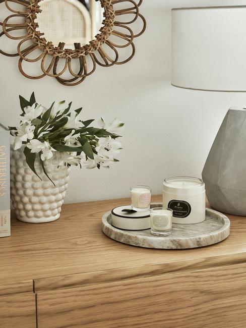 Drewniana komoda z wazonem z kwiatami i tacą ze świecami