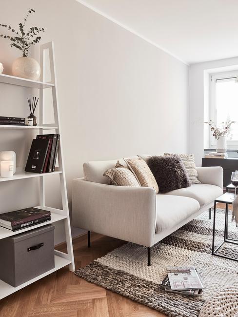 Salon urządzony w duńskim stylu z jasną sogą i białym regałem