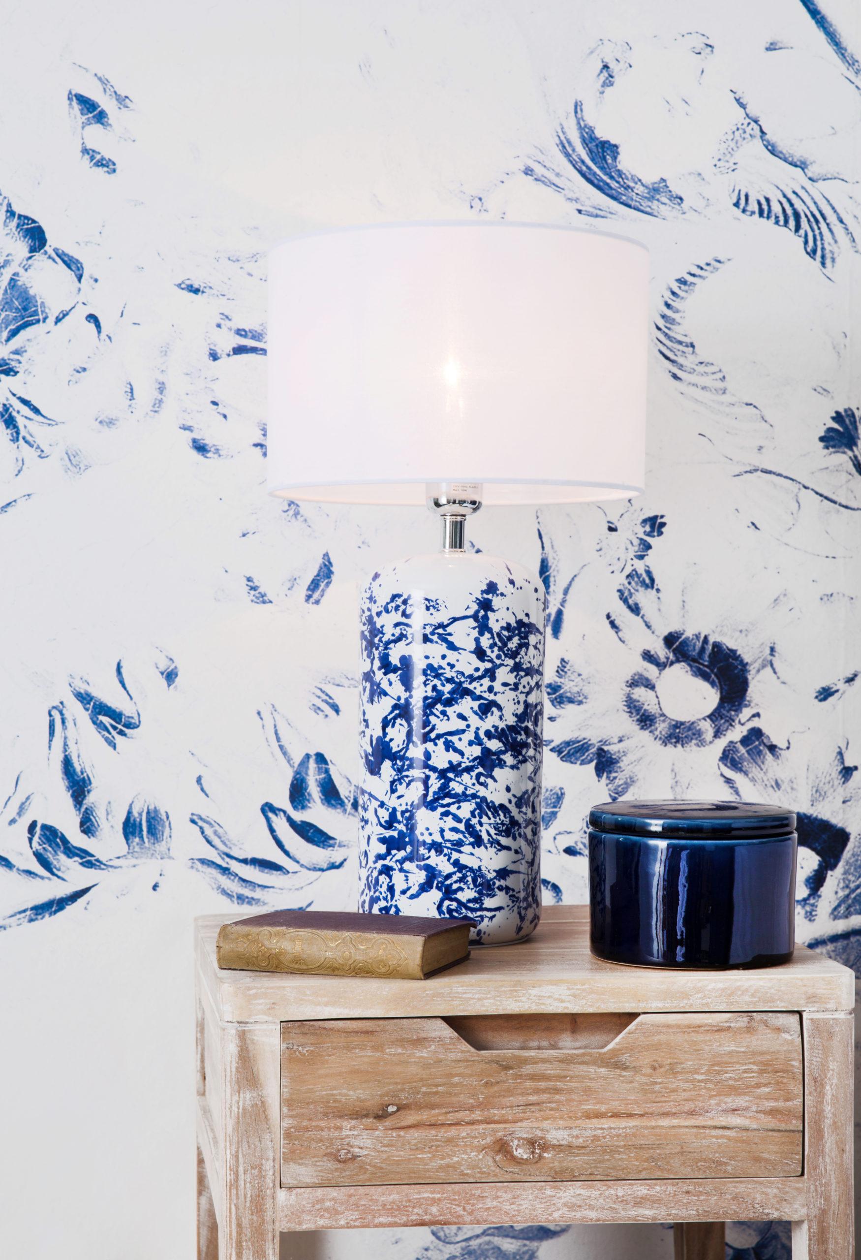Biało-niebieska tapeta z drewnianym stolikiem nocnym oraz lampą
