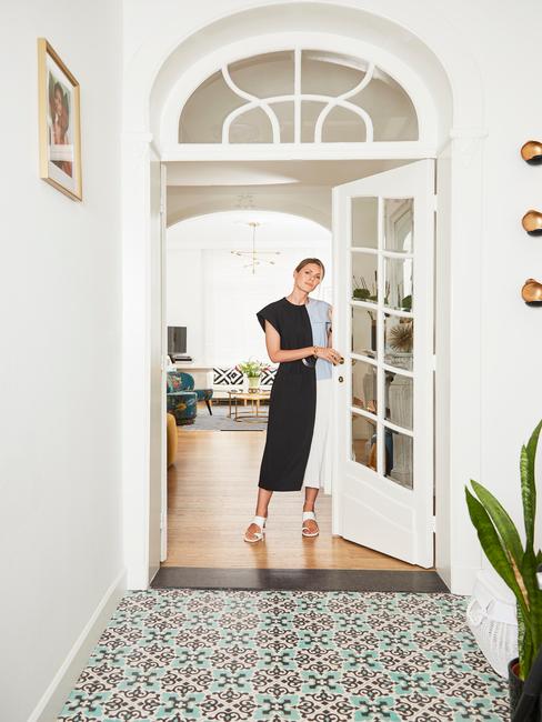 Kobieta stojąca przy białych drzwiach