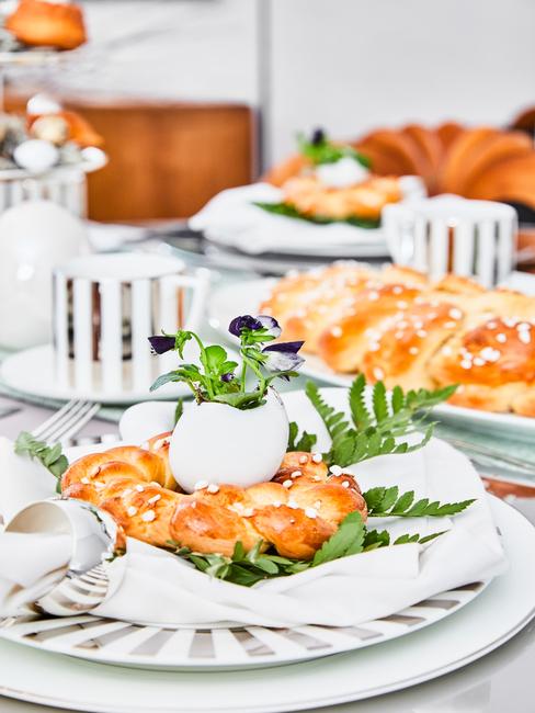 Udekorowany stół za pomocą wypieków, zastawy oraz roślin