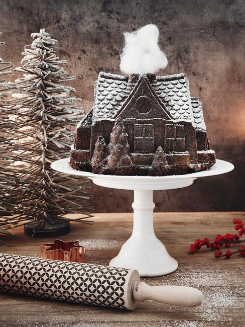 Biała patera z domkiem z pierwnika oraz dekoracjami świątecznymi