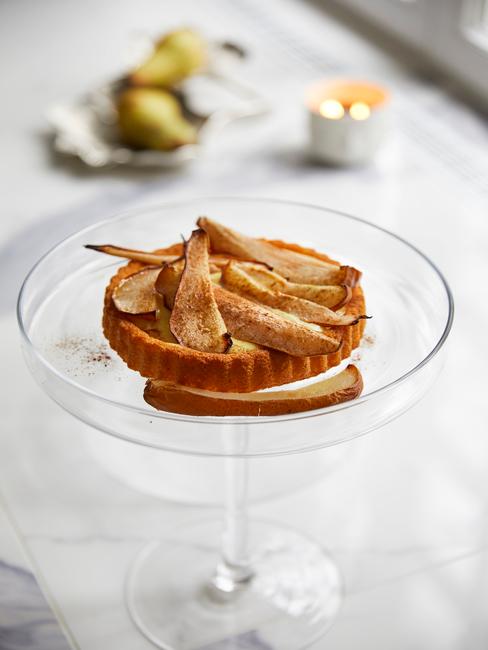 Mała tartaletka z gruszkami umieszczona w kieliszku od martini