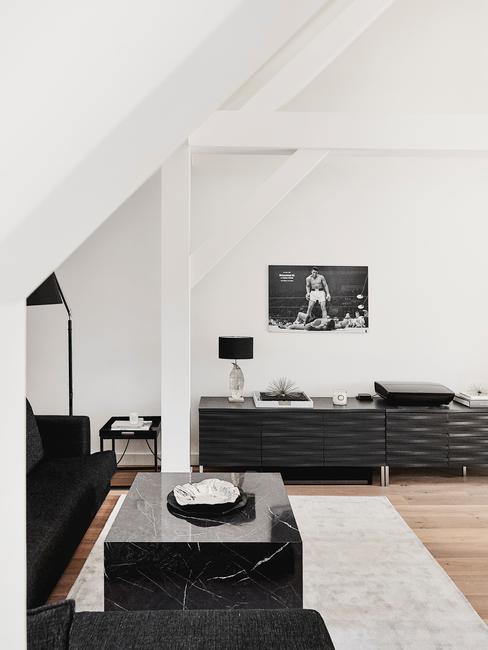 Minimalistyczny czarno-biały pokój z czarną sofą, stolikiem z czarnego marmuro oraz komodą