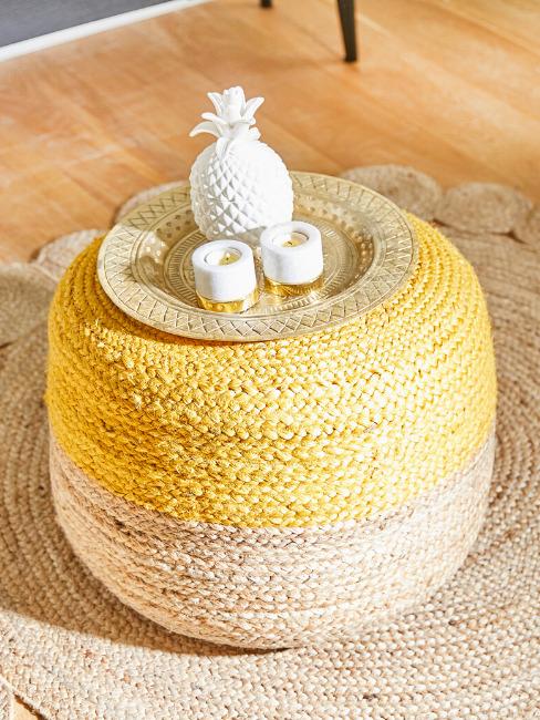 Pleciony żółty kosz na przechowywanie na którym jest ułożona misa dekoracyjna