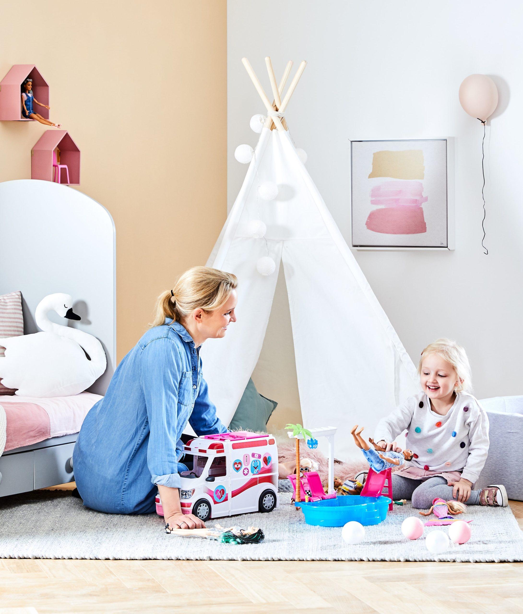 Mama z córką siedzące na podłodze w pokoju dziecięcym