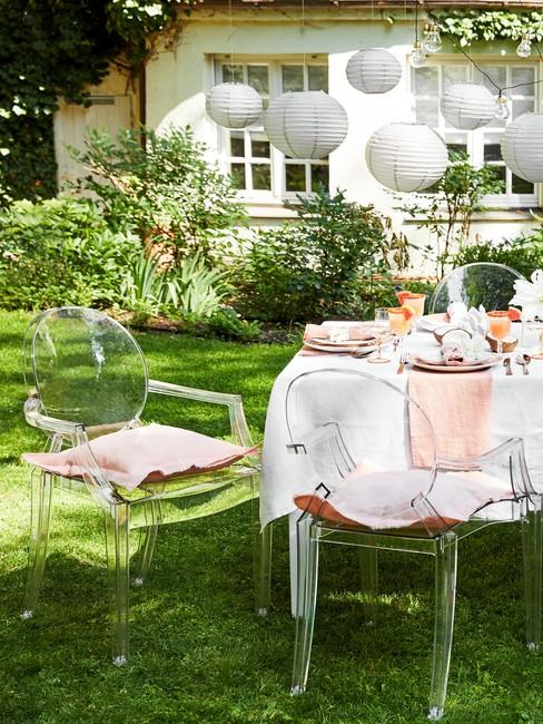 Fragment zastawionego stołu na garden party ustawiony przed skalniakiem