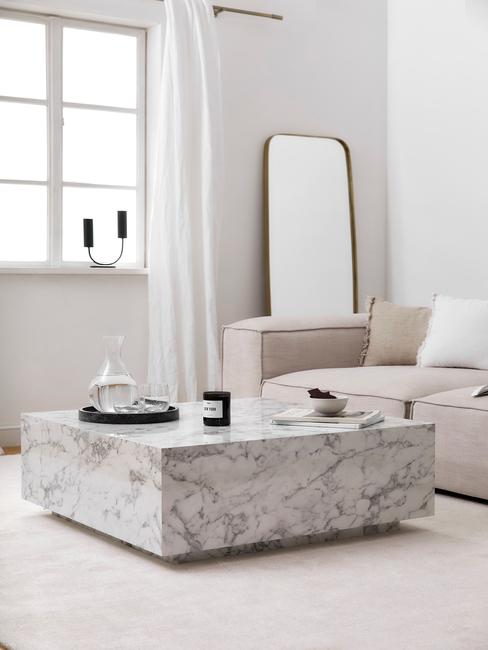 Biały salon z marmurowym stolikiem kawowym, beżową kanapą oraz dekoracjami