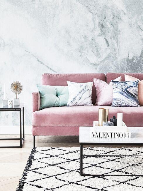 Subtelny, kobiecy salon z różową sofą i tapetą z motywem imitującym marmur