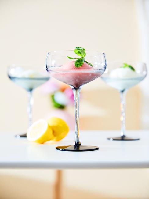 Trzy szklane kieliszki do martini z lodami