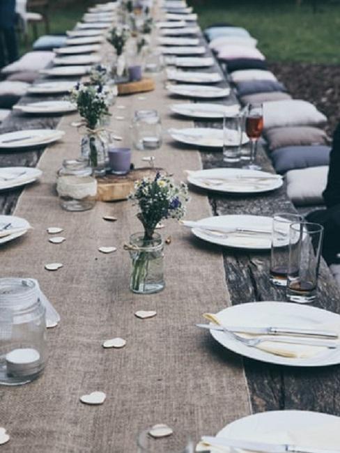 Zastawiony stół weselny w stylu rustykalnym z drobnymi dekoracjami w kształcie serca