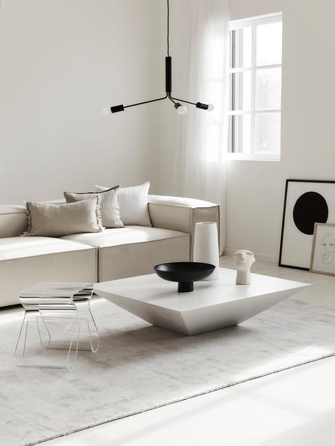 Jasny salon z biała sofą, białym stolikiem kawowym oraz dekoracjami