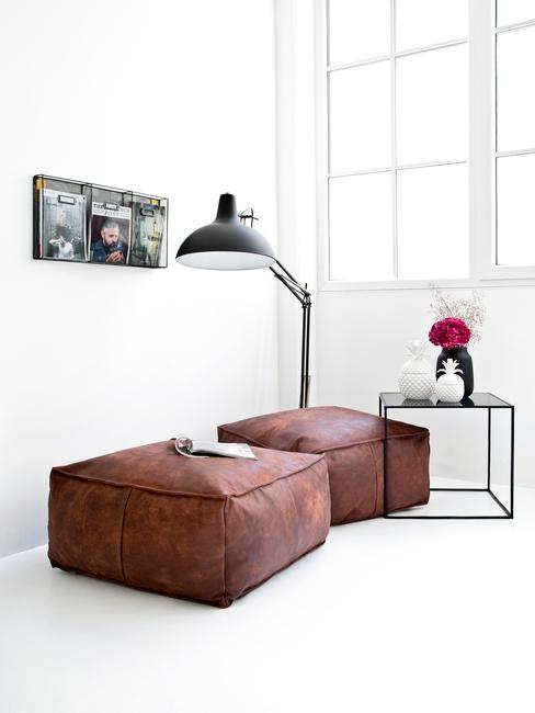 Minimalistyczne wnętrze z dwoma, skórzanymi pufami oraz stolikiem kawowym