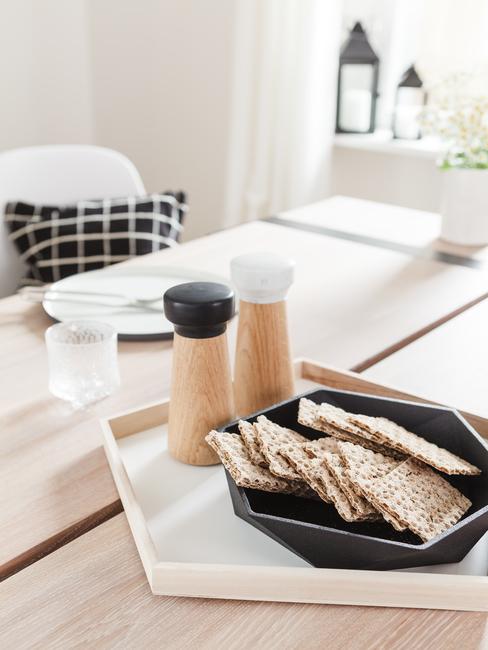 Zbliżenie na drewniany stoł na którym jest prosta, zastawa kuchenna