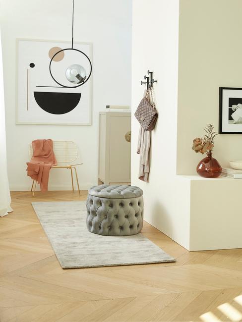 Biały korytarz z dekoracjami i aksamitnym pufem