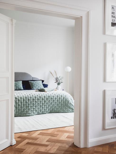 Biała sypialnia z łożkiem o akamitej narzucie