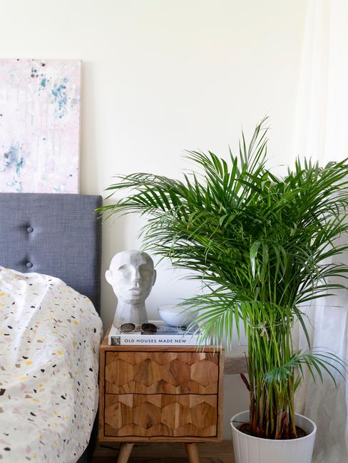 Biała sypialnia z dużym kwiatem, stoliczkiem oraz łóżkiem