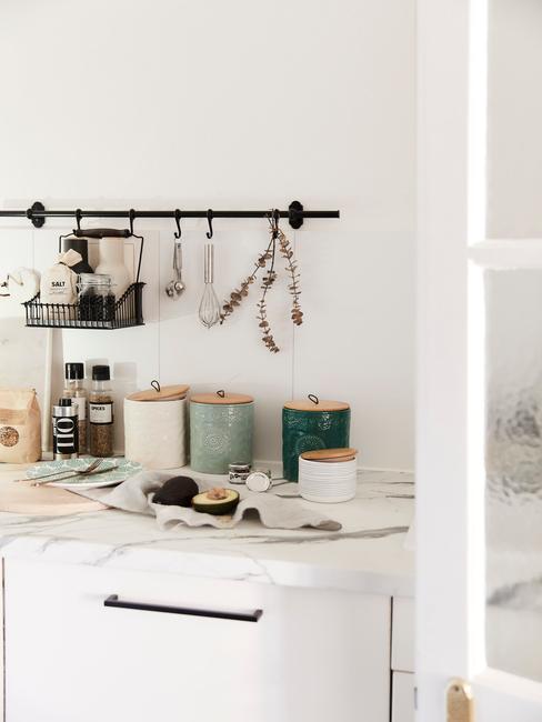 Zbliżenie na marmurowy blat z pojemnikami do przechowywania i relingiem