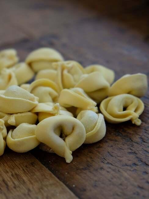 Zbliżenie na surowe tortellini na drewnianej desce