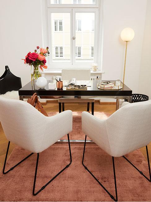 Gabinet w domu z czarnym stołem, białymi krzesłami i dekoracjami w złocie