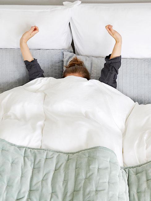 Kobieta przeciągająca się w łóżku