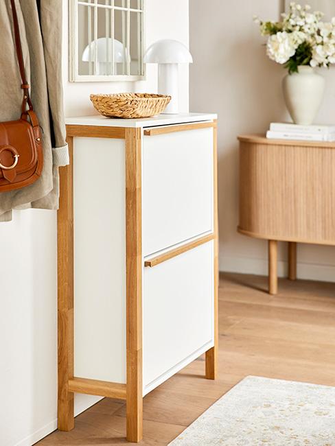 Biała, wąska szafka na buty w jasnym przedpokoju w stylu skandynawskim