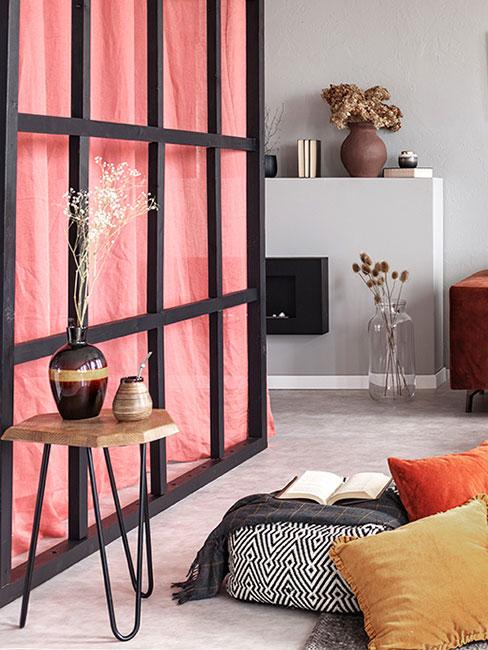 ścianka w stylu japońskim z różową zasłoną w salonie z białym minimalistycznym kominkiem, poduszkami podłogowymi i stolikiem z drewna