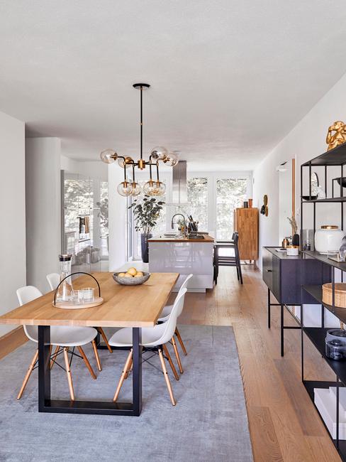 Jadalnia w stylu skandynawskim z drewnianym stołem, białymi krzesłąmi oraz metalową półką