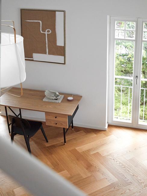 Kącik do pracy z drewnianym biukiem oraz czarnym krzesłem