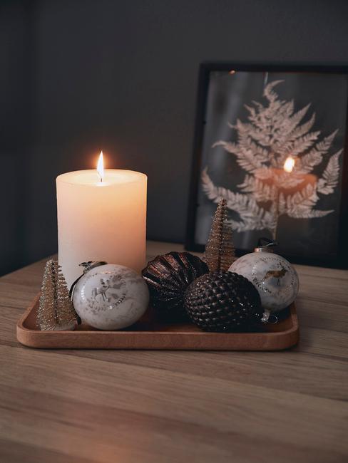 Świąteczna taca dekoracyjna z bombkami choinkowymi, świeczką oraz małymi choinkami na komodzie