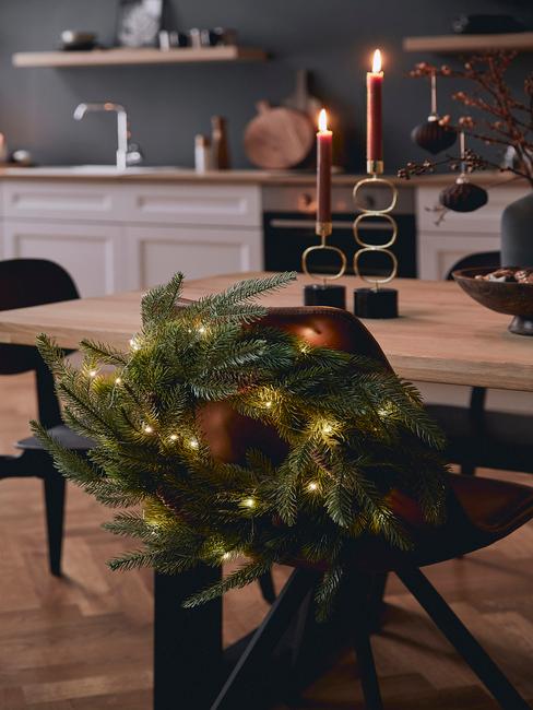 Zbliżenie na wieniec świąteczny doczepiony do tapicerowanego krzesła w jadalni