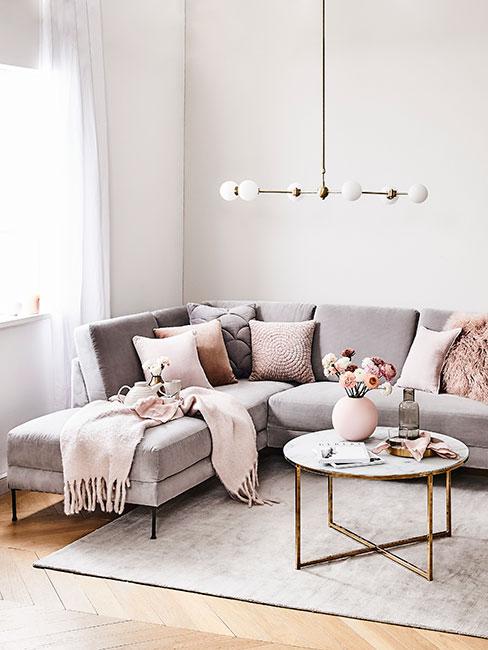 Szara sofa narożna z aksamitu z pastelowymi poduszkami