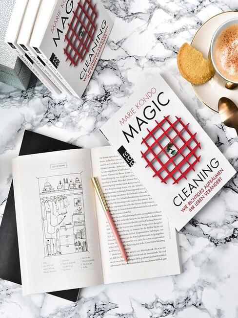 marie kondo Zbliżenie na stolik kawowy z marmurowym blatem na którym znajduje się książka Marie Kondo