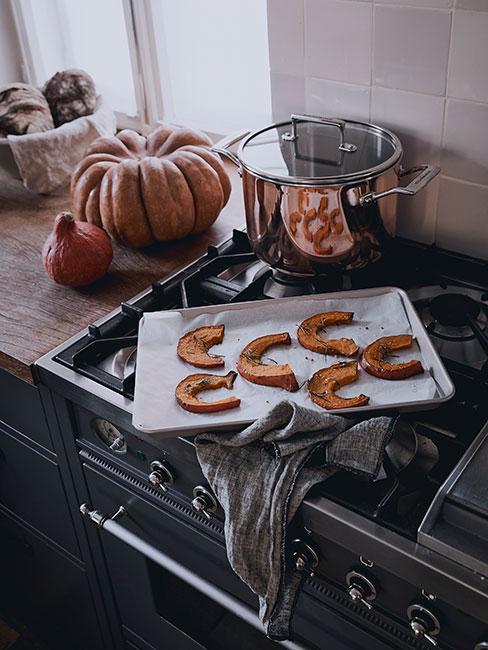 plasterki dyni na ciemnej kuchence w kuchni rustykalnej