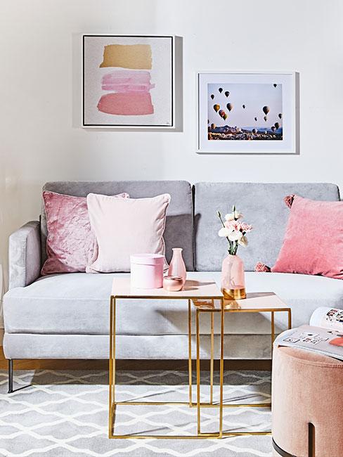 szara sofa z aksamitu z różowymi poduszkami i złotymi stolikami pomocniczami w stylu glamour