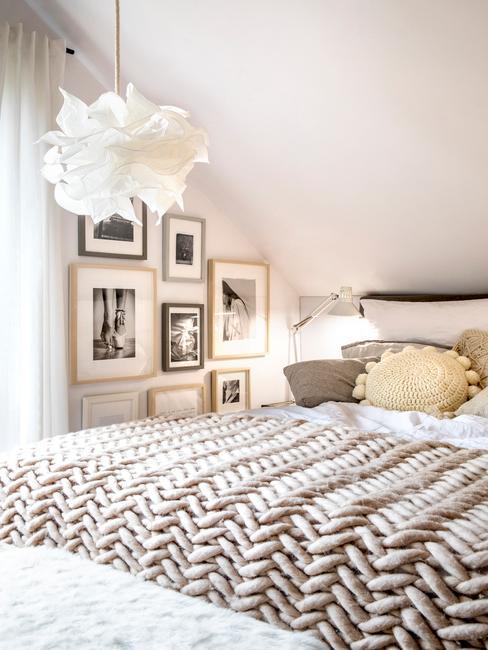 Sypialnia boho na poddaszu w odcieniach beżu i grubą narzutą