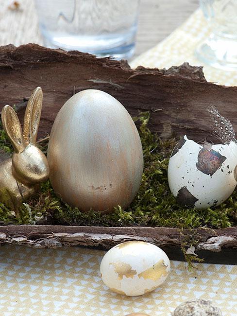 zbliżenie na pozłacane jajko obok złotego królika