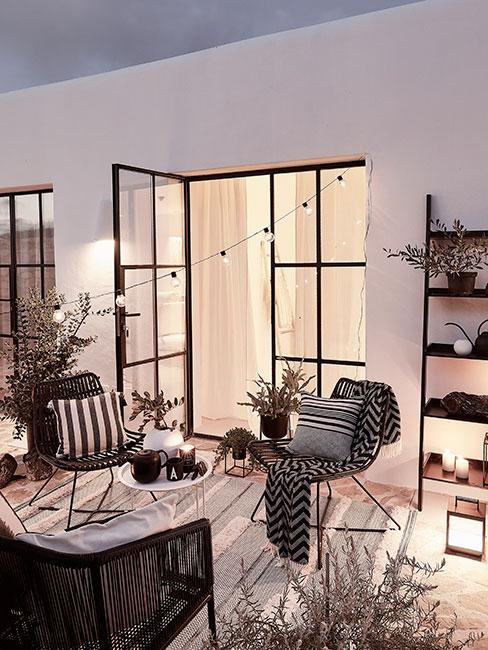 Widok na jasny taraz s meblami ogrodowymi i dywanem