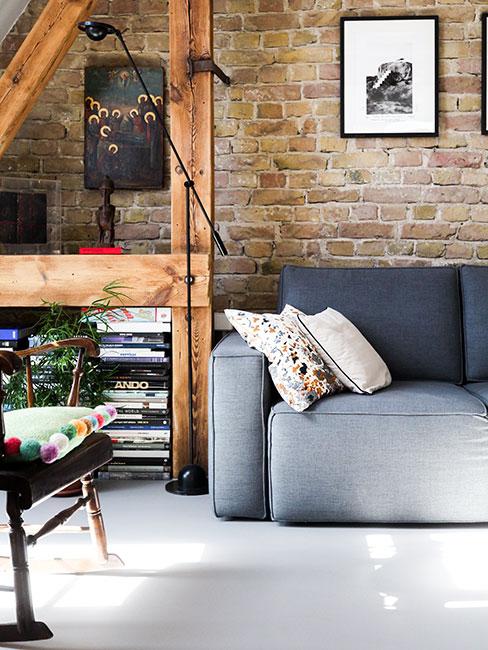 salon w stylu industrialnym z szarą sofą i ceglaną ścianą
