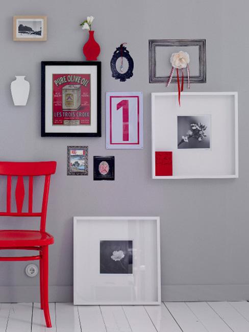 Galeria ścienna obrazów w różnej wielkości na szarej ścine obok czerwonego krzesła