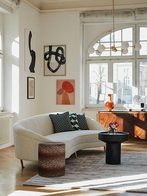 modne wnętrza salon w stylu retro z beżową sofą nerką i zielonymi poduszkami