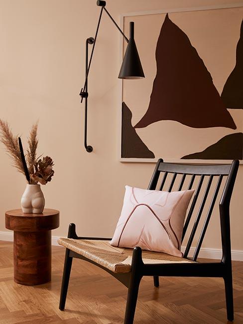 Krzesło z poduszką z motywem ciała kobiety obok stolika z wazonem w kształcie kobiety