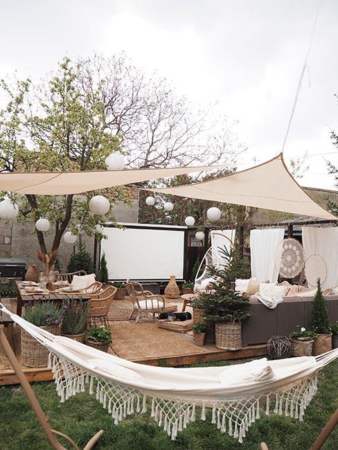 Kino w ogrodzie z lampionami i parasolami i dekoracjami w stylu boho